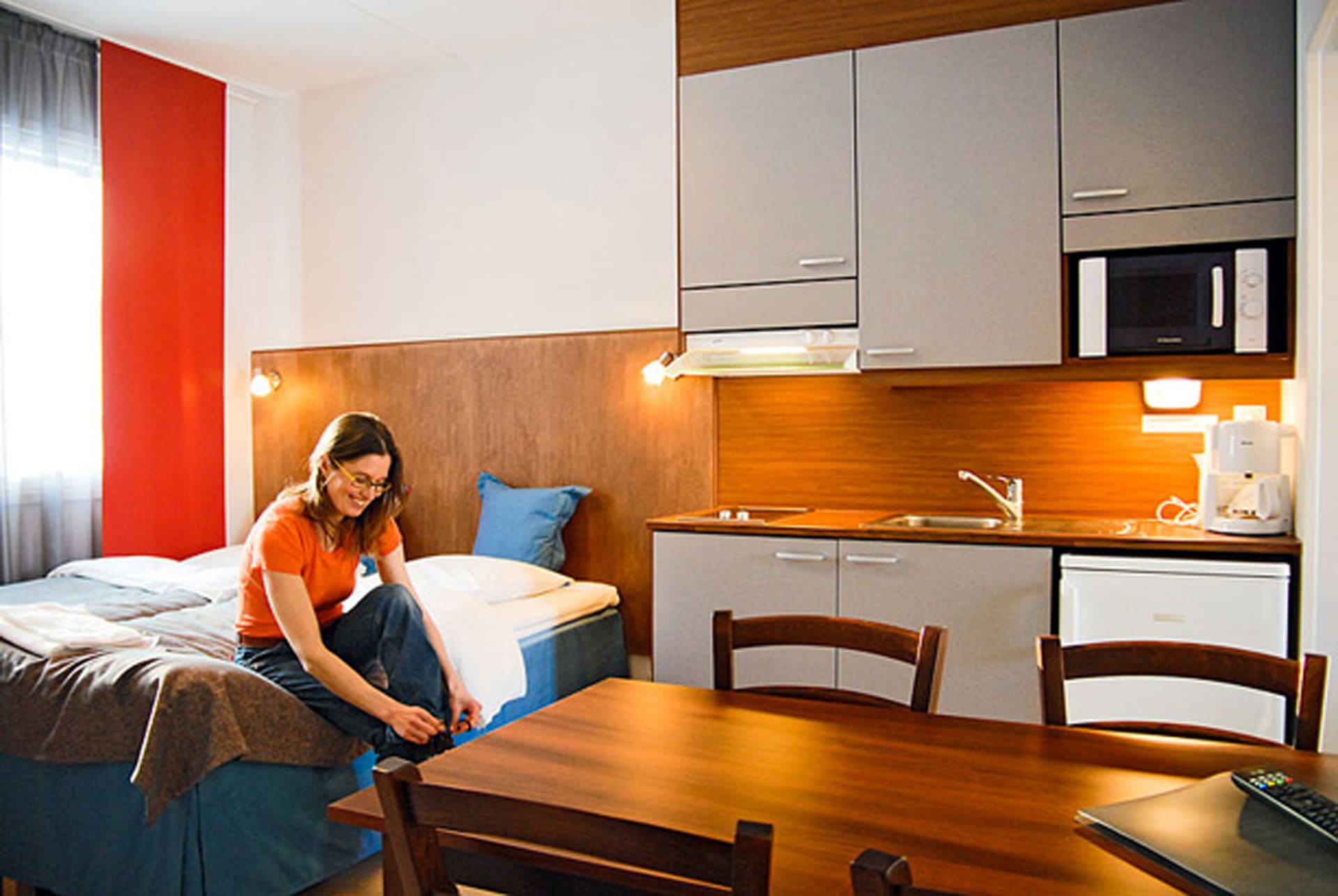 Woman sitting on a bed in a hotel room